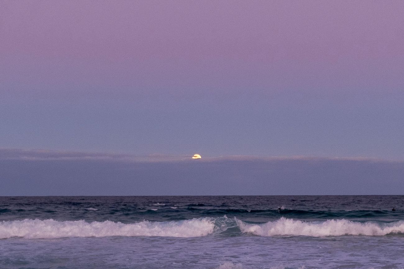 Ocean waves under a soft purple evening sky